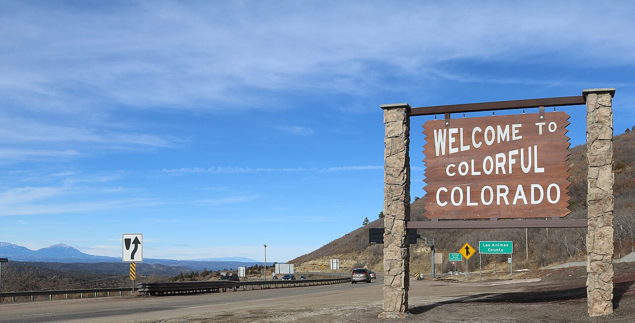 Signs at Raton Pass on the New Mexico-Colorado state line along Interstate 25; the border sits just in front of the 'Welcome to Colorful Colorado' sign (photo by Jeffrey Beall, Jan 18, 2020).